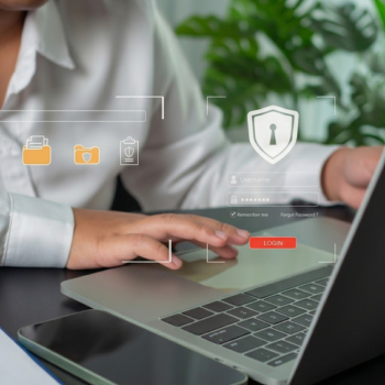 A person using a laptop with digital overlays of a secure login screen, a shield icon with a keyhole, and protected document folders.