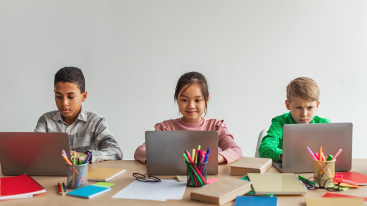 three-school-kids-using-laptops-learning-school