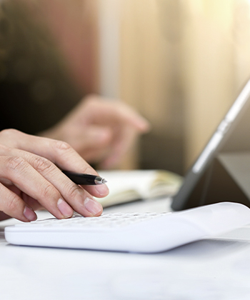 Hand with pen on calculator