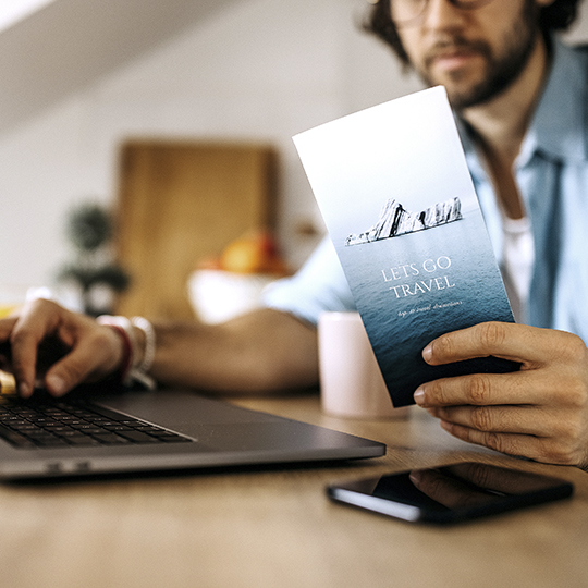homme avec un ordinateur portable et une brochure