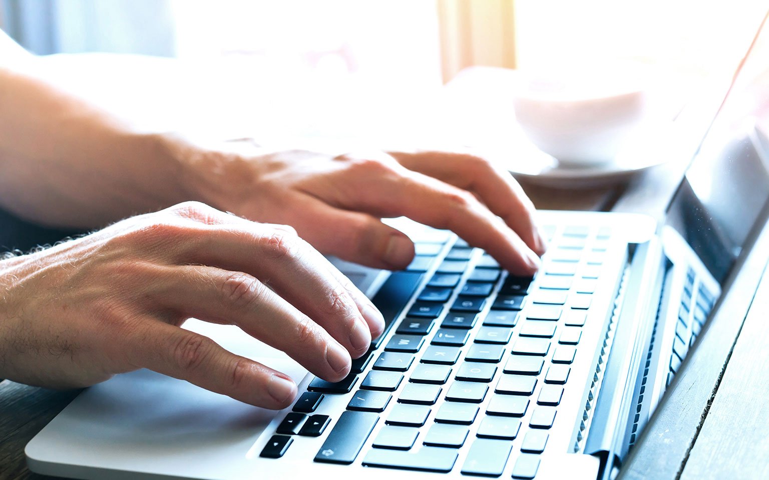 close up of hands typing on a laptop