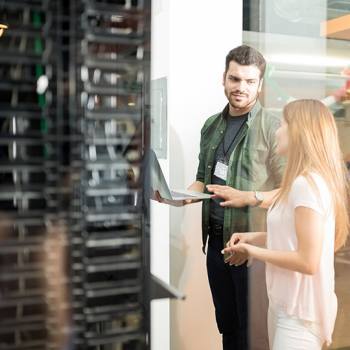 Man and woman in front of computer servers