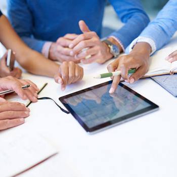 Infographies close up of people around a tablet