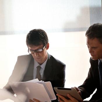 Financial Services Two men looking at paperwork and tablet